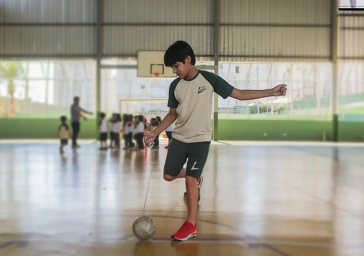 Aluno do Colégio Liceu Barretos dominando a bola na quadra da escola