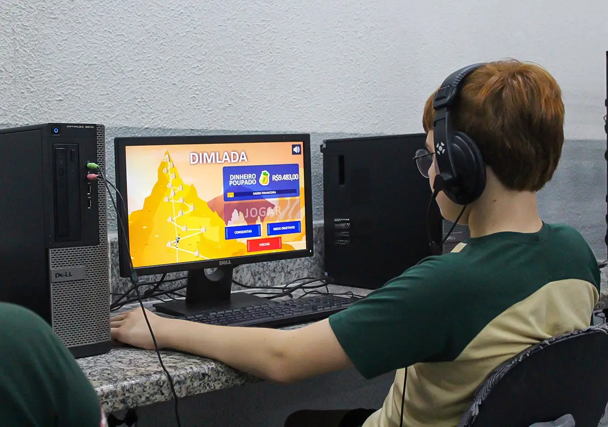 Aluno no laboratório de informática usando a plataforma de educação financeira Bolodim