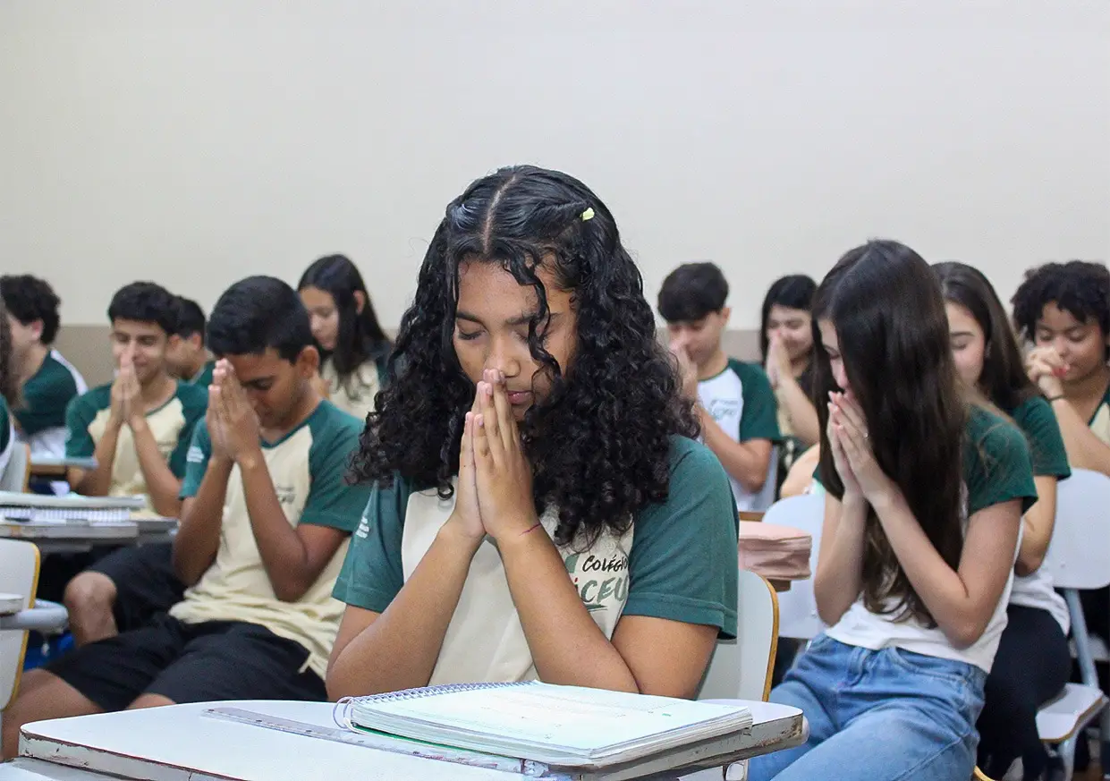 Alunos do Ensino Médio em momento de oração na sala de aula