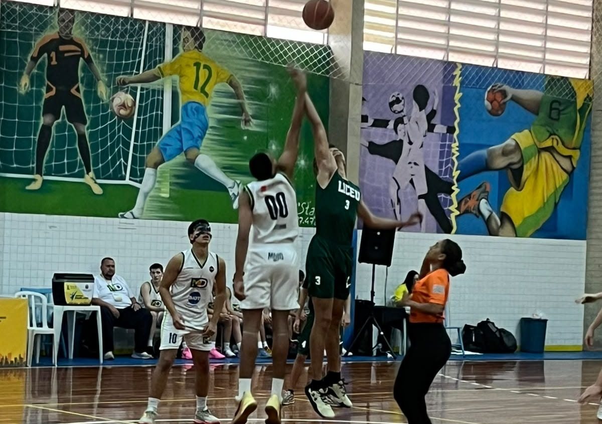 Alunos do Colégio Liceu Barretos disputando a bola no início de uma partida de basquete, na quadra da escola