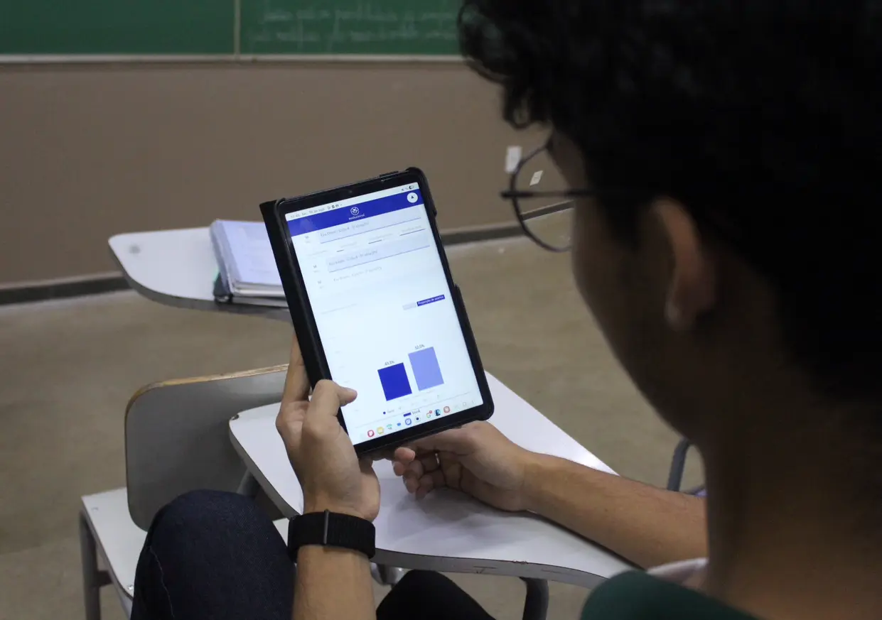 Aluno do Ensino Médio consultando no tablet o painel de desempenho do Evolucional